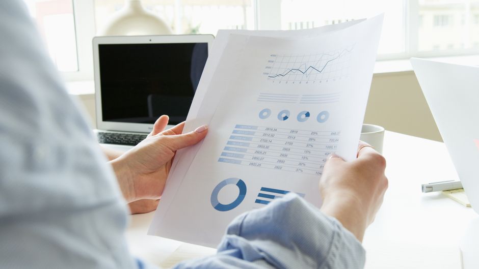 person reviewing printed data charts at desk