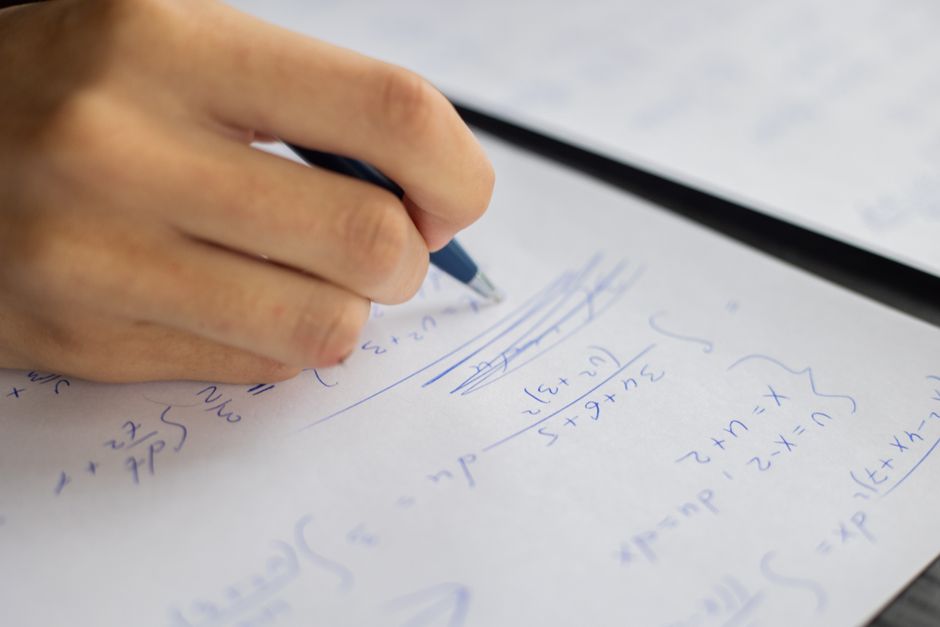 hand solving math problem on paper