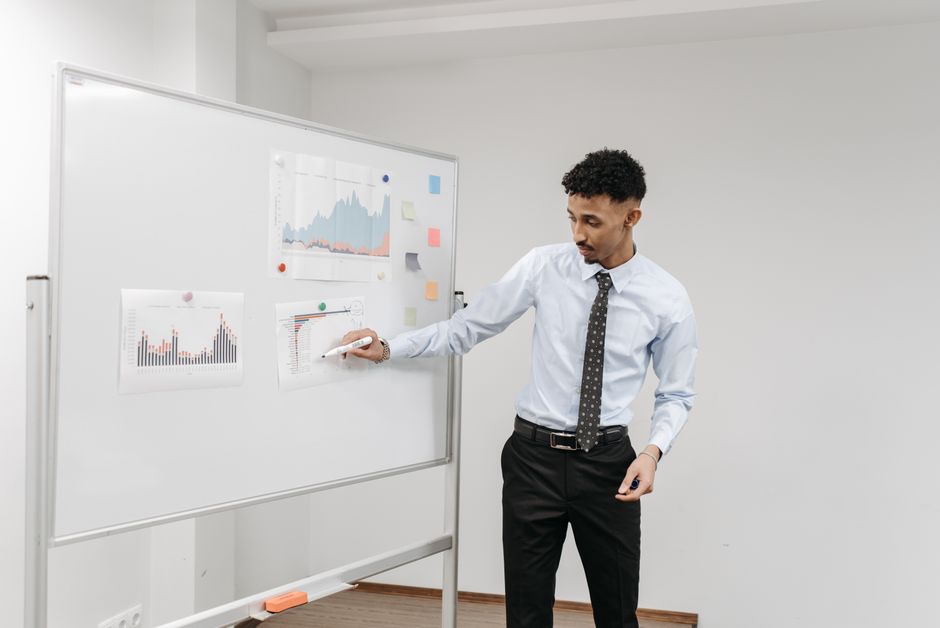 data scientist writing on whiteboard with charts