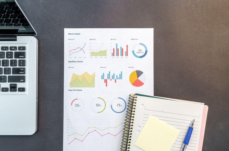 laptop with data charts on desk
