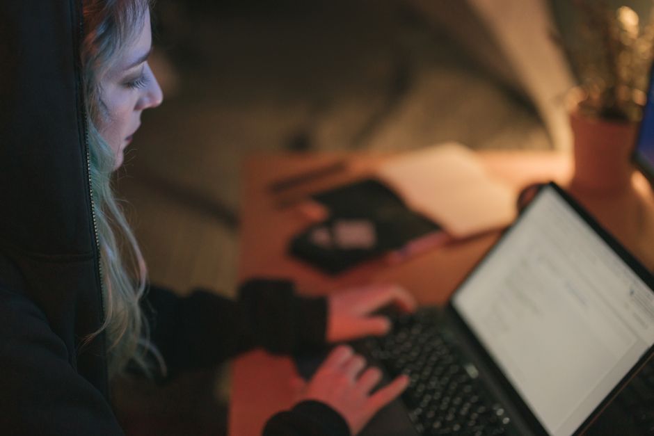 researcher at laptop in dark office