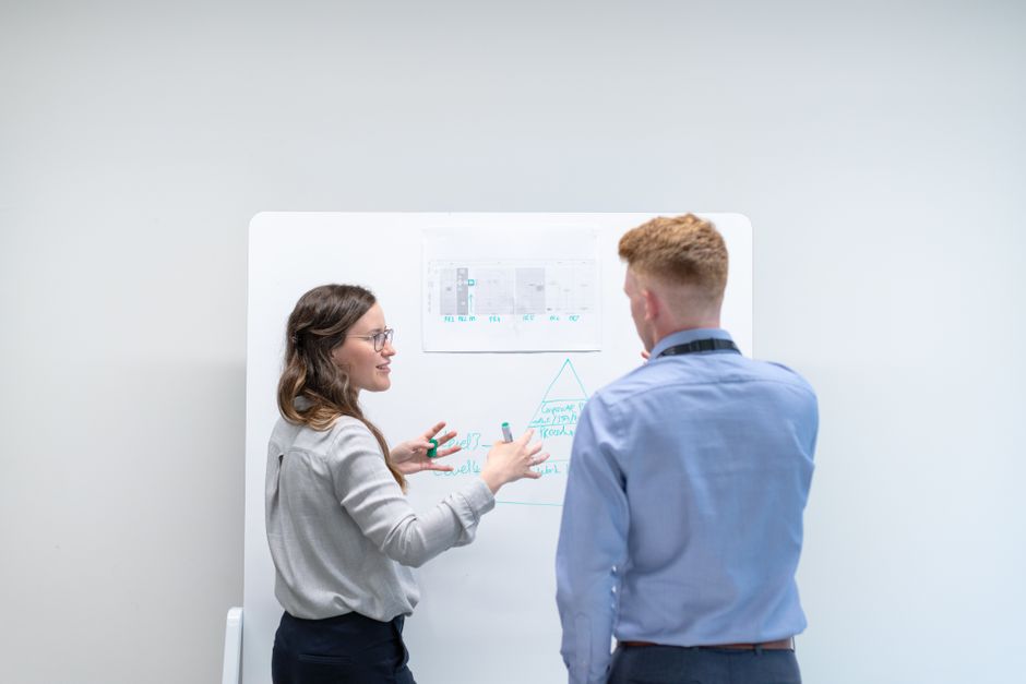 person explaining whiteboard diagram to interviewer