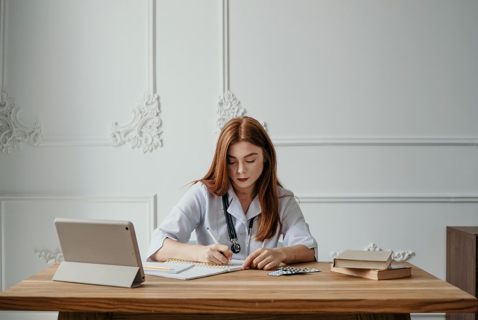 researcher writing notes at desk