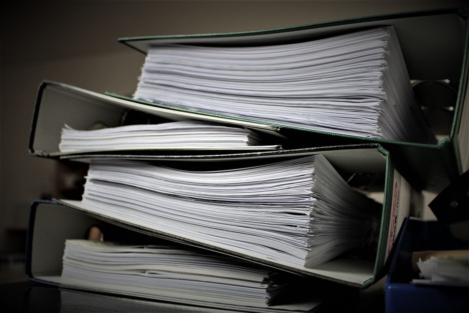 person reading policy binder at desk