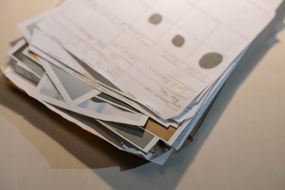 stack of printed customer service emails on desk