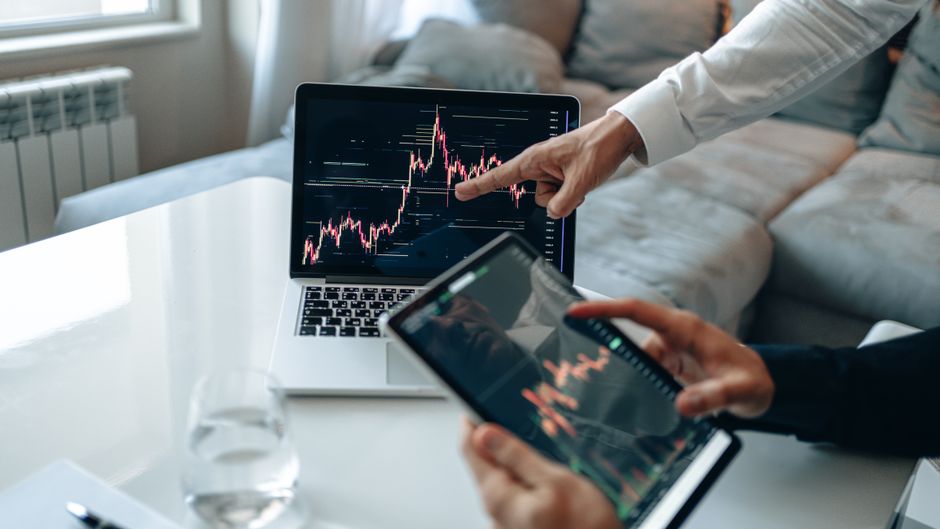 researcher comparing two charts on laptop