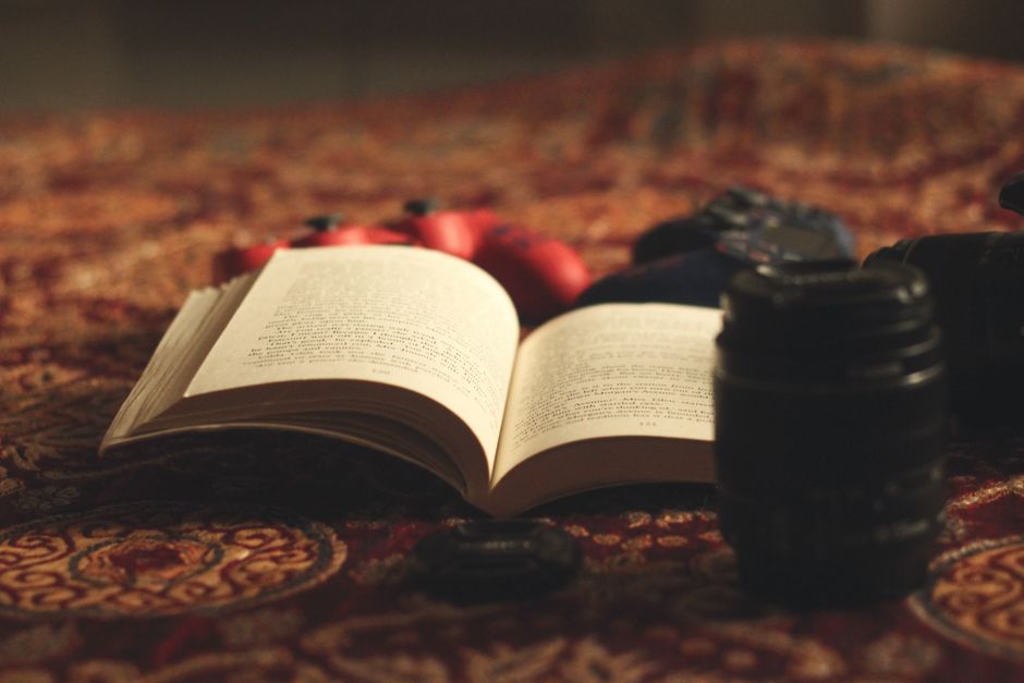 camera lens beside open book