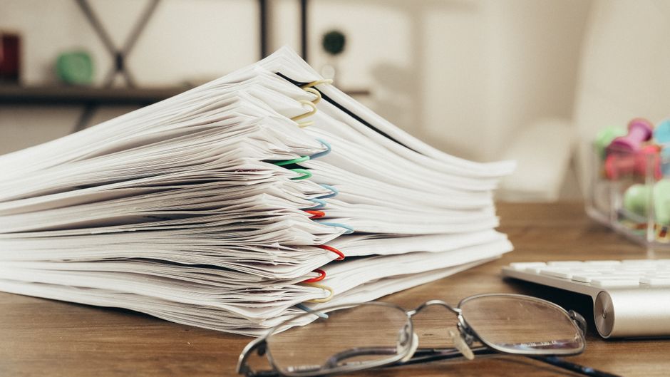 stacks of paper documents on desk