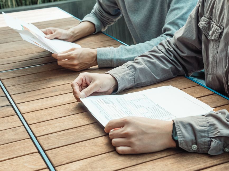 two people comparing documents side by side
