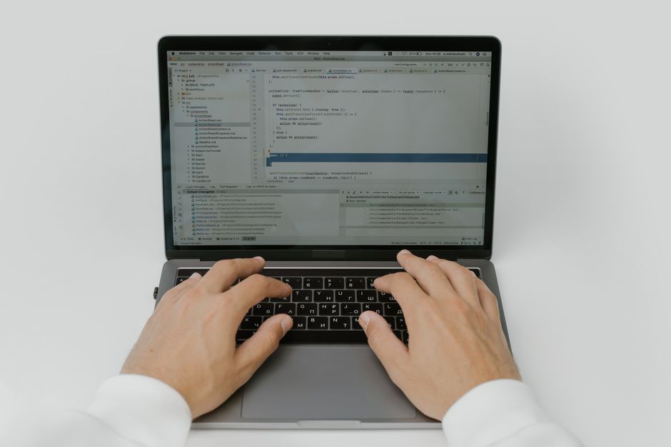 person typing on laptop with code editor open