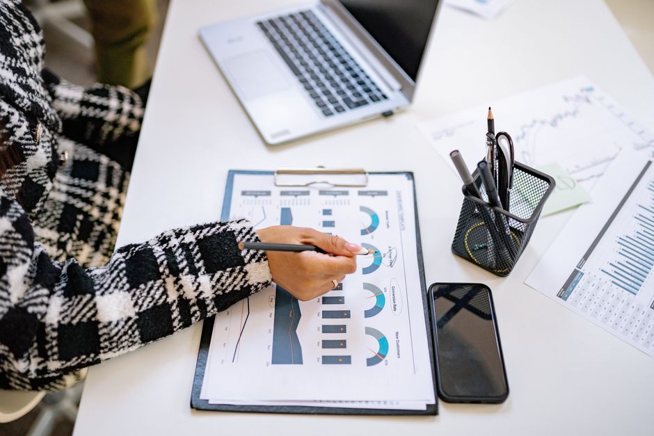 person reviewing charts at laptop desk