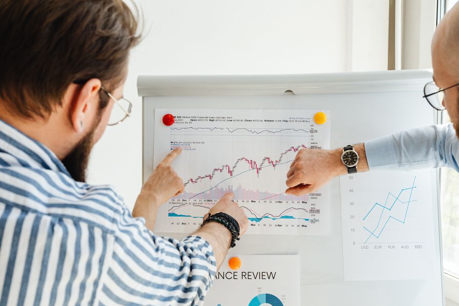 two colleagues discussing data on whiteboard