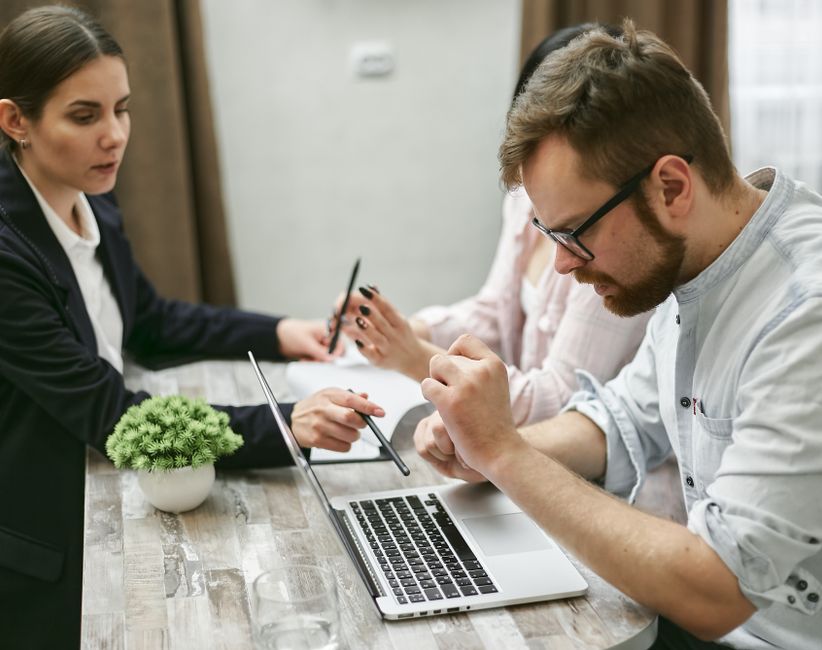 small team meeting around laptop