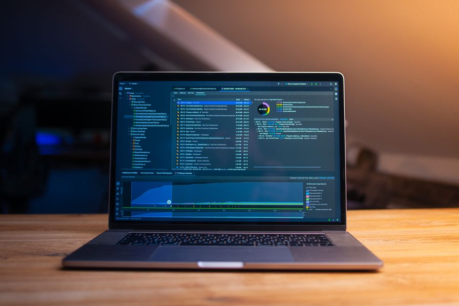 laptop with code and charts on desk