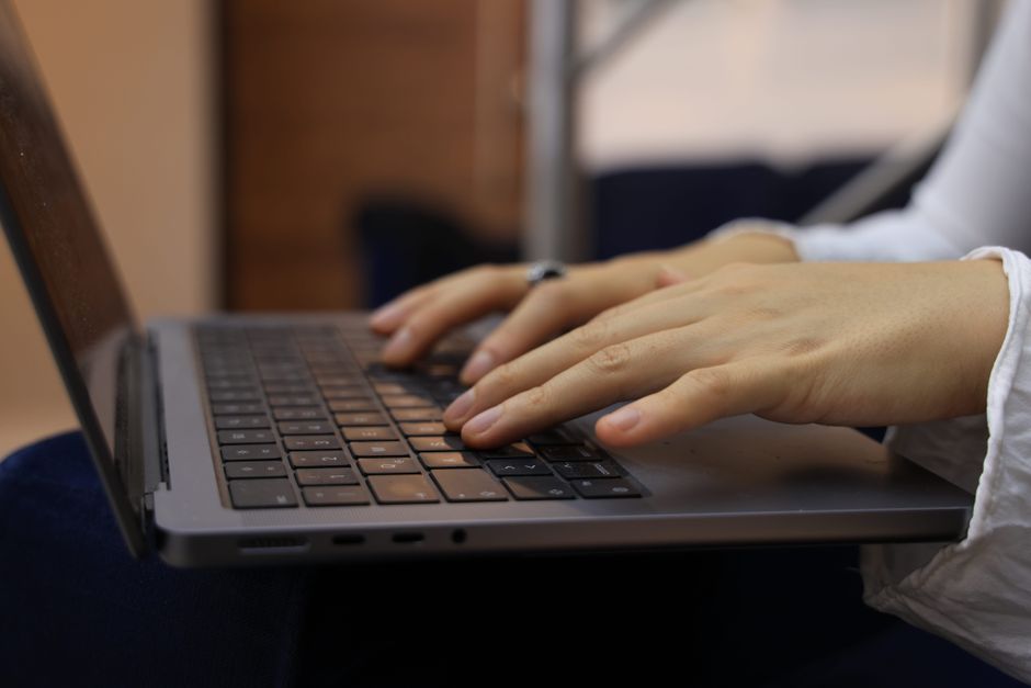 hands typing on laptop keyboard