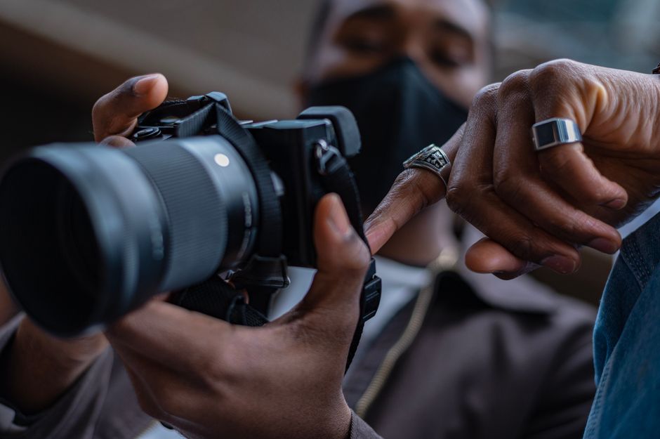 hands adjusting camera lens settings